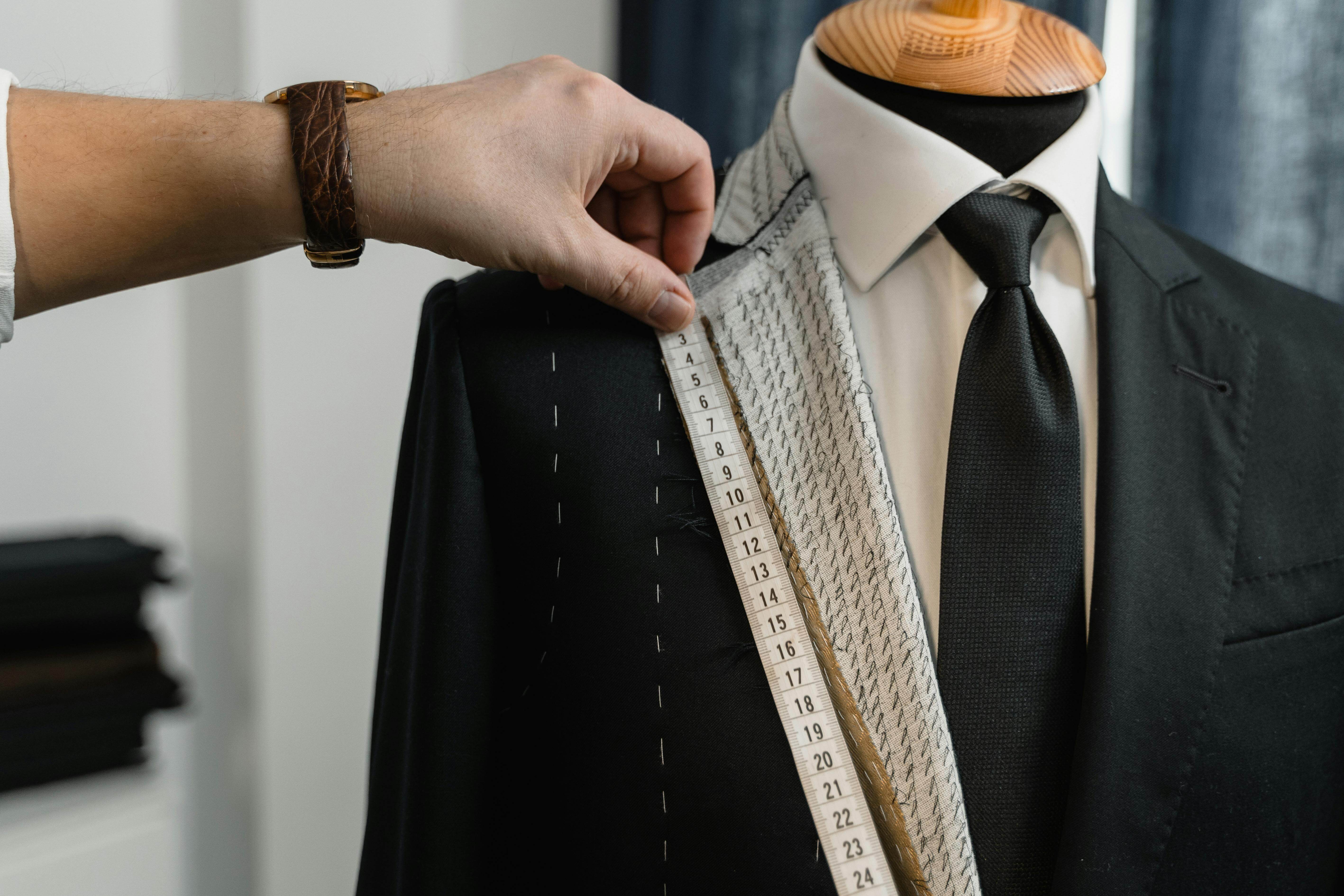 Close-up of clothing alterations on a garment, with tailor adjusting fabric